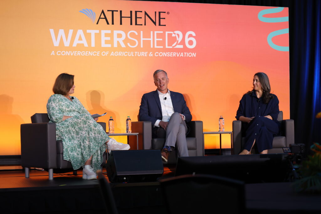 Group of panelists talking on stage at Athene Watershed26